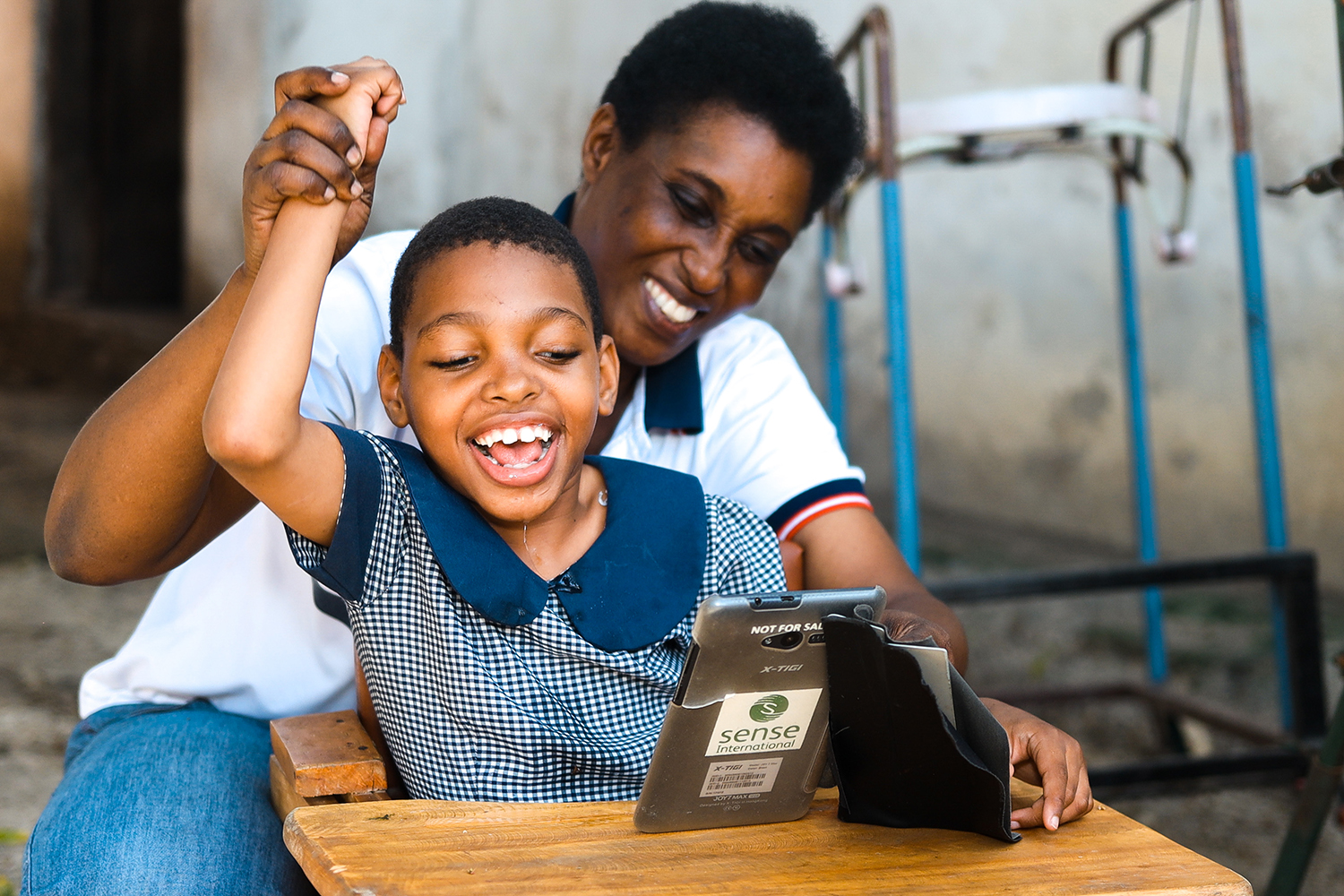 A young girl is supported to learn from an electronic tablet by her mother. A young girl is supported to learn from an electronic tablet by her mother.