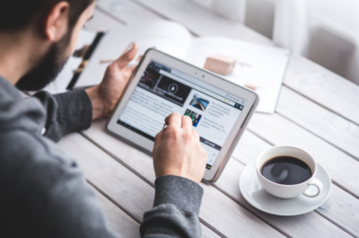 Man holding a tablet scrolling through a website. Man holding a tablet scrolling through a website.
