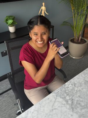 Milagro, a young woman with deafblindness, listening to an article on Insight, using assistive technology on her phone. Milagro, a young woman with deafblindness, listening to an article on Insight, using assistive technology on her phone.